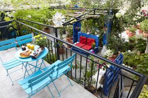 een balkon met stoelen en een tafel met eten erop bij House with Yard by the Hill in Athene