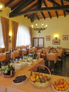 een eetkamer met tafels en stoelen met fruitschalen bij Albergo Miniere in Traversella