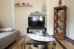 een woonkamer met een tv en een glazen tafel bij House with Yard by the Hill in Athene