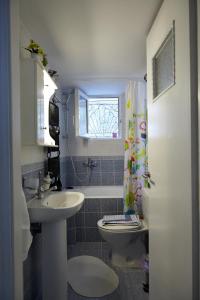 a bathroom with a sink and a toilet and a window at House with Yard by the Hill in Athens