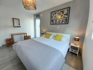 una camera da letto con un grande letto bianco con cuscini gialli di Guest House Dragić a Zara (Zadar)