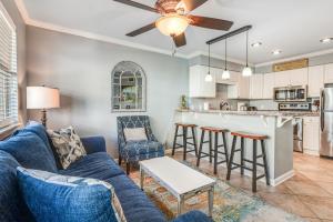 a living room with a blue couch and a kitchen at Summer Breeze 21 in Orange Beach
