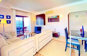ein Wohnzimmer mit weißen Sofas und einem TV in der Unterkunft Villa Ágatha, vacaciones en familia en Lanzarote in Playa Blanca