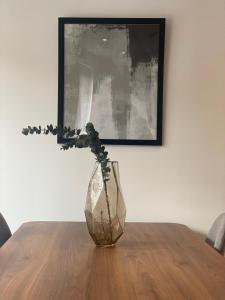 a vase sitting on top of a wooden table at Icona - Stylish apartment in brand new development! in York