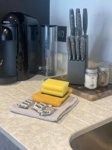 a kitchen counter with a sink with knives and towels at Icona - Stylish 2 bed apartment in York