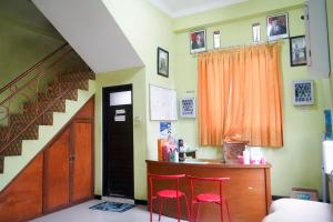 Pare的住宿－Homestay Kampung Inggris SYARIAH，一间设有两张红色椅子和一张书桌的房间,以及楼梯