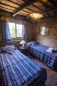 1 Schlafzimmer mit 2 Betten in einem Zimmer mit einer Decke in der Unterkunft Rumi Huasi in Agua de Oro
