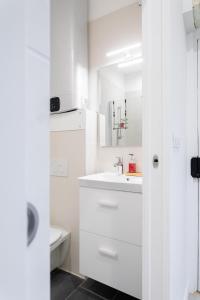 a white bathroom with a sink and a toilet at Jardin Secret Studio Terrasse Panier Vieux-Port Marseille in Marseille