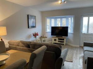 uma sala de estar com um sofá e uma televisão de ecrã plano em The Sorting House em Hunstanton