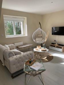 ein Wohnzimmer mit einem Sofa und einem Tisch in der Unterkunft Escapade amoureuse - Jaccuzi et Sauna PRIVÉ in Fontenoy