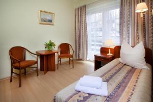 a bedroom with a bed and a desk and a window at Mauritius Ośrodek Szkolenia Sportu i Rekreacji in Szklarska Poręba