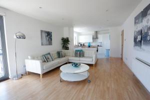 a living room with a white couch and a table at Edinburgh Waterfront Apartments in Edinburgh