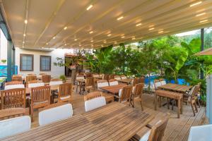 an outdoor patio with wooden tables and chairs at Mavi Deniz Konuk Evi in Selimiye
