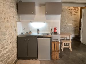 eine Küche mit einer Spüle, einem Herd und einem Tisch in der Unterkunft L'Etoile in Nîmes