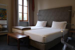 Habitación de hotel con 2 camas y mesa en Settecento Hotel, en Presezzo