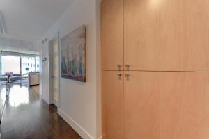 a hallway with wooden cabinets and a painting on the wall at Les Immeubles Charlevoix - Le 760310 in Quebec City