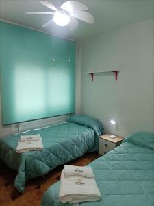 a room with two beds and a ceiling fan at Apartamentos San Antón 2 in Córdoba +17 photos