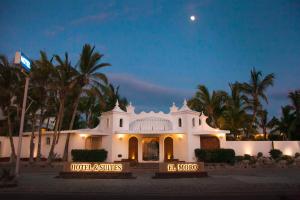 a white building with palm trees at night at Hotel & Suites El Moro in La Paz +31 photos