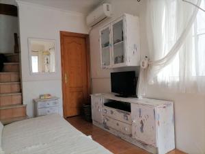 1 dormitorio con 1 cama y vestidor con TV en Andalusien pur auf drei Etagen en Torrox