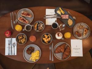 a wooden table with many plates of food on it at Dandy Hotel & Kitchen in Paris
