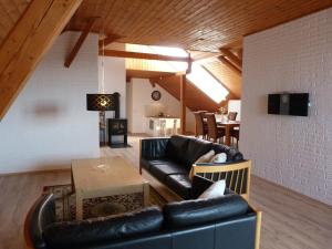 a living room with a black leather couch and a table at Penzion Stranny in Stranný
