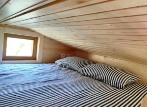 ein großes Bett in einem Holzzimmer mit Fenster in der Unterkunft Tiny-river in Falaën