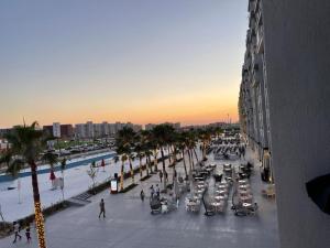 uitzicht op een straat met mensen en palmbomen bij Amazing view apartment in Golf Porto Marina. in El Alamein