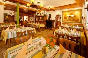 a restaurant with tables and chairs and a fireplace at Waldgasthof Wildbad in Burgbernheim