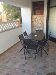 a wooden table and chairs on a patio at Apartman Roko in Novalja