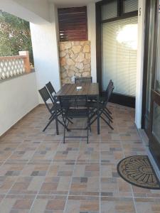 a wooden table and chairs on a patio at Apartman Roko in Novalja +39 photos