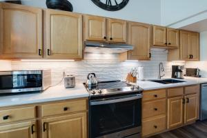 Overlook Athletic Club HeliportInner Circle Serenity Condo: Great Breck Location的配有木制橱柜和炉灶烤箱的厨房