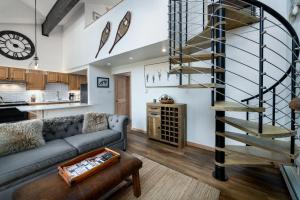 a living room with a couch and a spiral staircase at Inner Circle 15 Serenity Condo Great Breck Location in Breckenridge