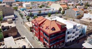 a red building with a red roof in a city at Apartamento Coral in Santa Maria