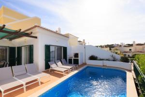 a villa with a swimming pool and a house at Vale Do Lobo Resort in Vale do Lobo