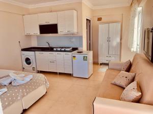 ErikliにあるERİKLİ SUNSHİNE HOLİDAY APART HOTElのソファとキッチンのあるリビングルーム