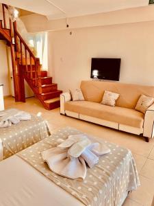 ErikliにあるERİKLİ SUNSHİNE HOLİDAY APART HOTElのベッド2台とソファのあるリビングルーム