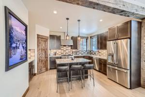 a kitchen with a large island with bar stools at Deere Retreat Home: Hot Tub, Stylish in Overlook Athletic Club Heliport
