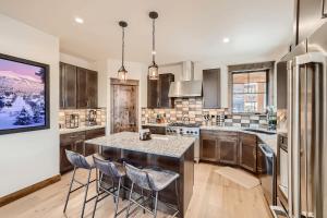a kitchen with a large island with bar stools at Deere Retreat Home: Hot Tub, Stylish in Overlook Athletic Club Heliport
