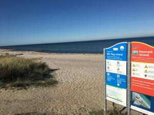a sign on a beach next to the ocean at Hasmark beach, nice house close to the beach. in Otterup