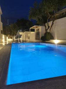 - une piscine éclairée en bleu la nuit dans l'établissement Pouletis Family Villas Sea Apartments, à Kalamata