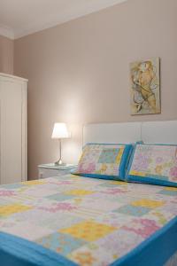 a bedroom with a bed with a colorful comforter at Casa das Rosas by MP in Vila Nova de Gaia