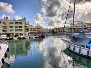 eine Gruppe von Booten, die in einem Yachthafen mit Gebäuden angedockt sind in der Unterkunft APARTAMENTO Daniel in Benalmádena