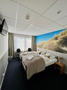 una camera d'albergo con due letti e un dipinto di una spiaggia di SEA YOU Hotel Noordwijk a Noordwijk aan Zee