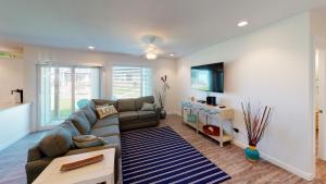 a living room with a couch and a tv at AH-B104 Newly Remodeled Ground Floor Condo, Overlooking PoolHot Tub in Port Aransas