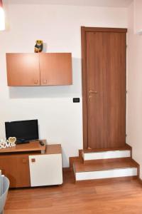Zimmer mit einer Tür und einem Schreibtisch mit einem TV in der Unterkunft Casa Lulù in Riva Ligure