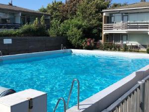 uma grande piscina azul em frente a uma casa em Vakantie appartement Chava WE09 em Westkapelle