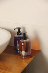 two bottles of soap sitting on a shelf next to a sink at El museo in Avila