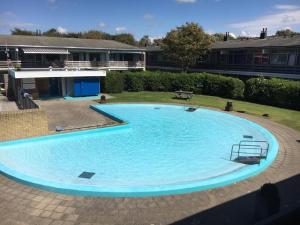 a large blue swimming pool in a yard at Vakantie appartement Chava WE09 in Westkapelle +8 photos