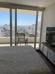 1 dormitorio con 1 cama, TV y ventana en Departamento Plaza Mexico, en Viña del Mar