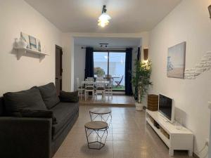 - un salon avec un canapé, une télévision et une table dans l'établissement Urb Las Cañas Apartamento B3, à Tarifa